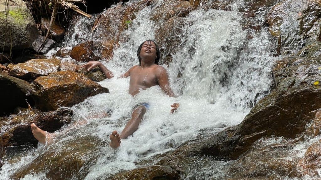 David sitting in a waterfall. 10 Reasons I loved living in Phuket