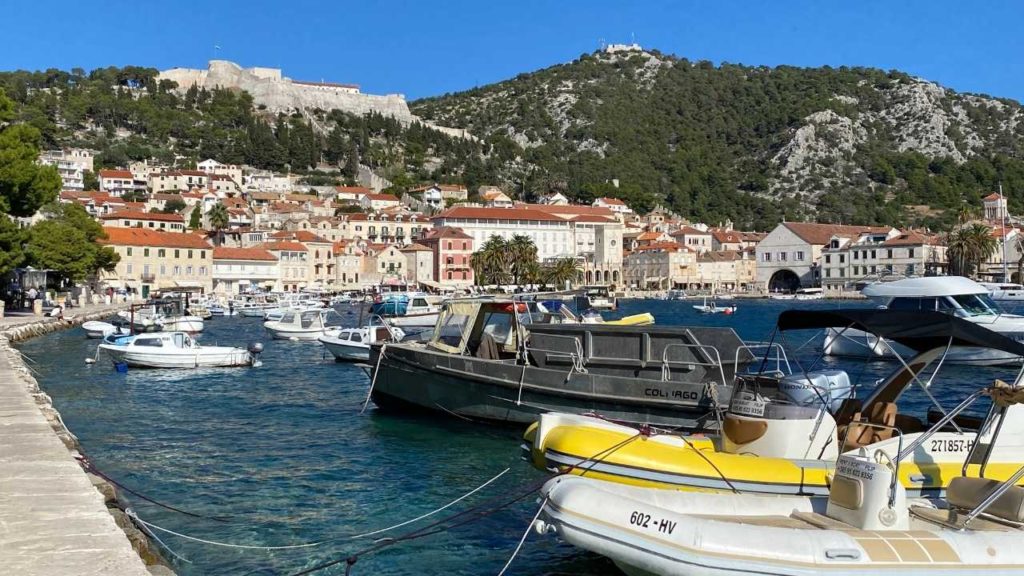 Hvar Island with boat docked in the marina and a fortress on the hill.