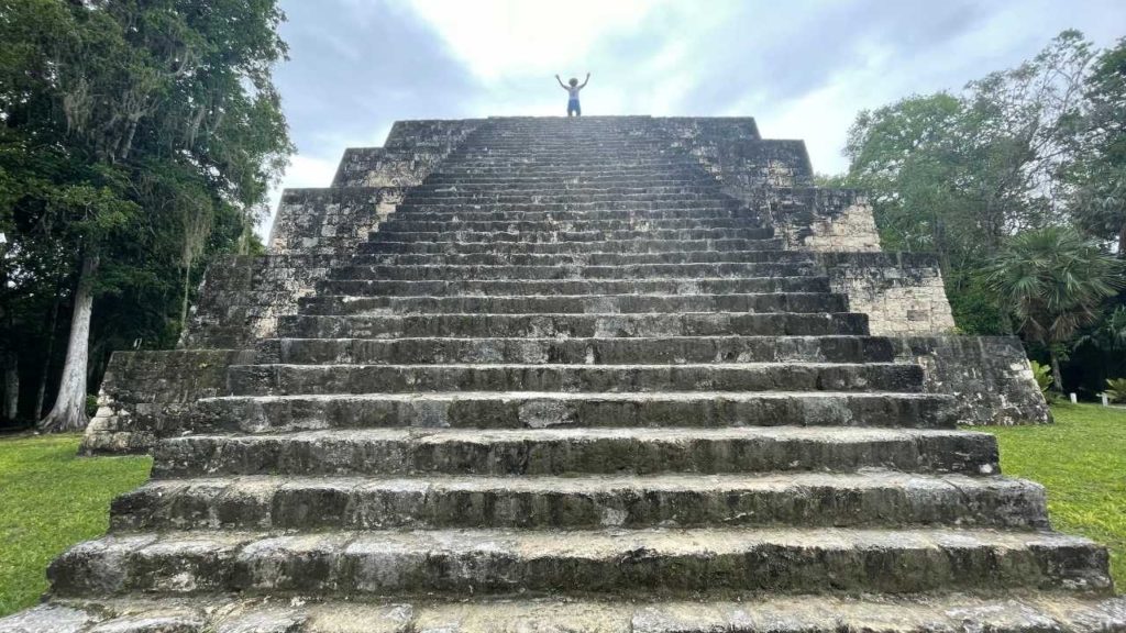 David standing at top of a temple at Yaxha