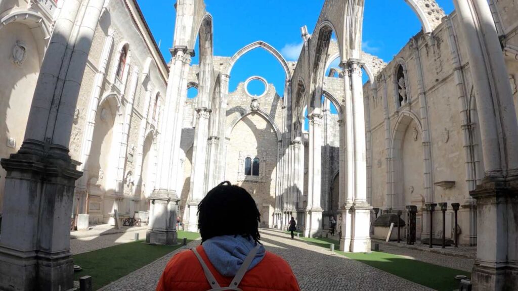 Man walking under the gothic arches of Carmo Convent in Lisbon Portugal