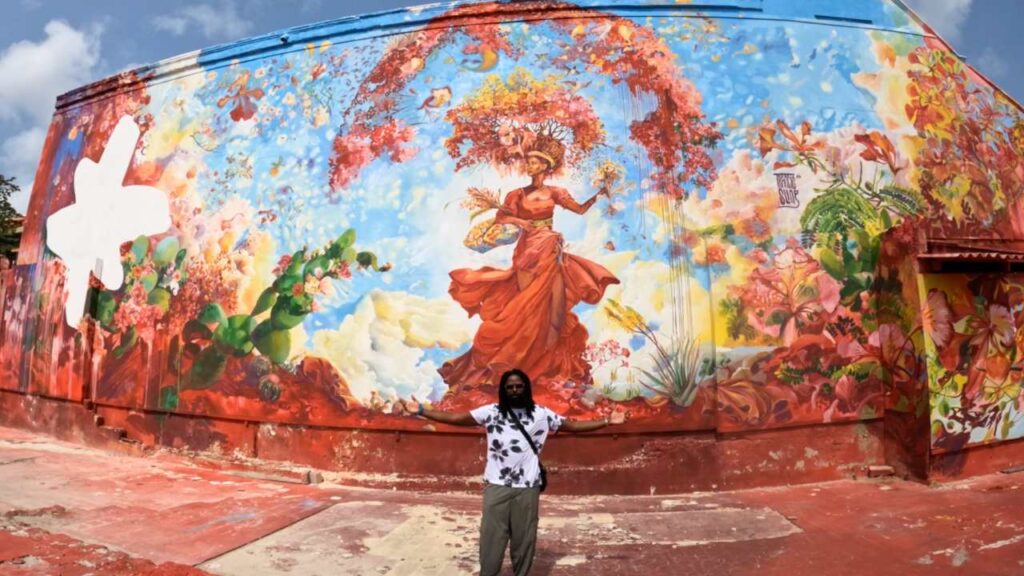 David Lucas standing in front the the Djosa mural another fun things to do in Willemstad Curacao