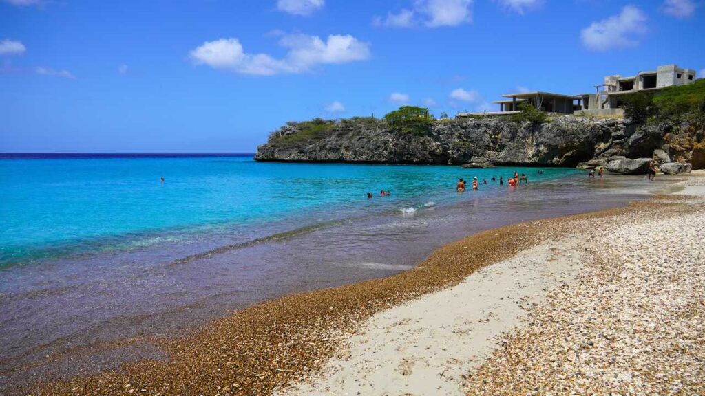 The blue water of Playa Jeremi with a rocky beach