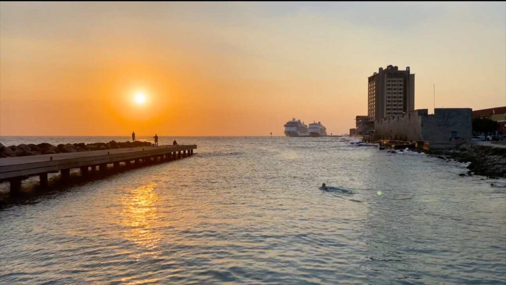 the sun setting with cruise ships in the distance at Punda Beach a great thing to do in Willemstad Curacao